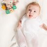 baby wrapped in white teddy alphabet shawl